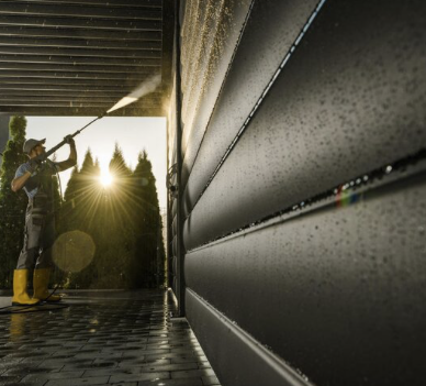 Fassadenreinigung Ein Mitarbeiter reinigt eine Fassade / Wand mit einem Hochdruckreiniger.