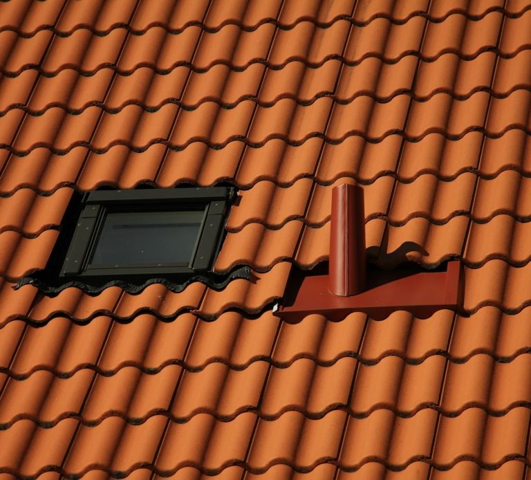 Dach-Reinigung Ein sauberes, gereinigtes Dach mit Ziegeln, einem Fenster und einem Schornstein.